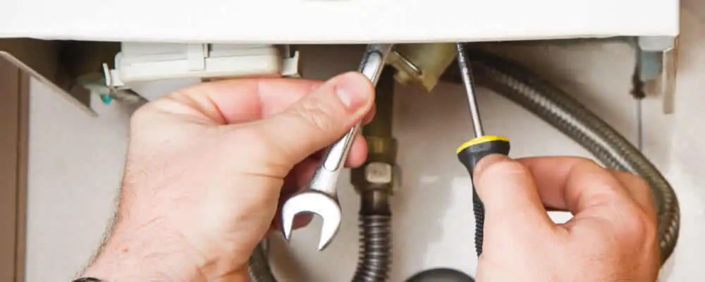 Boiler repair technician tightening pipe fittings and connections in Dayton, OH