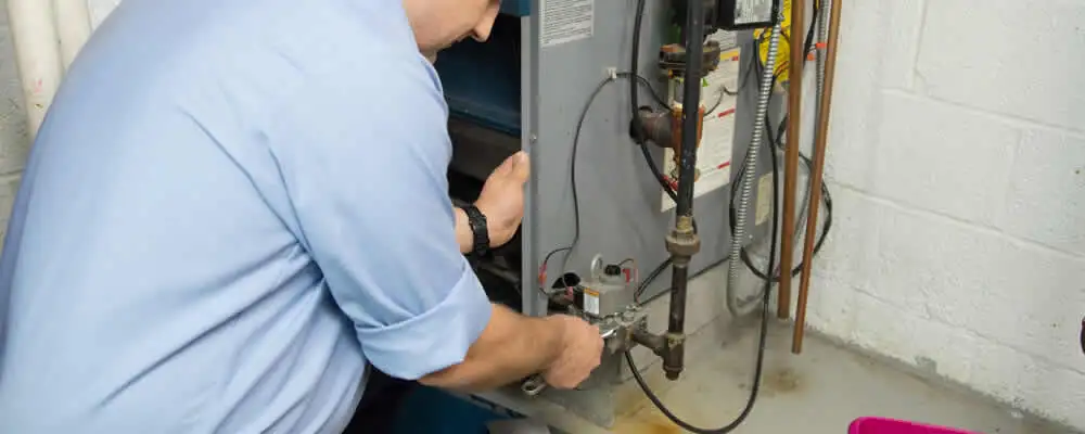 Furnace repair technician inspecting and servicing a home heating system in Dayton, OH