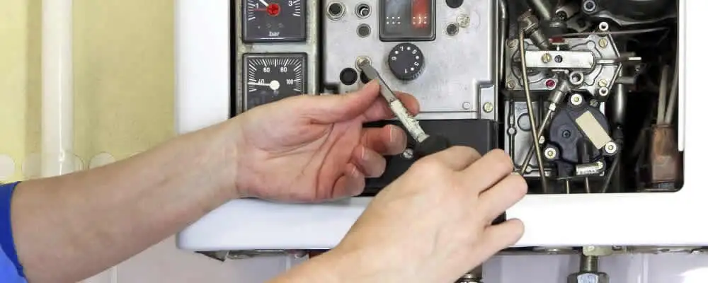 Heating repair technician adjusting boiler controls and components in Dayton, OH