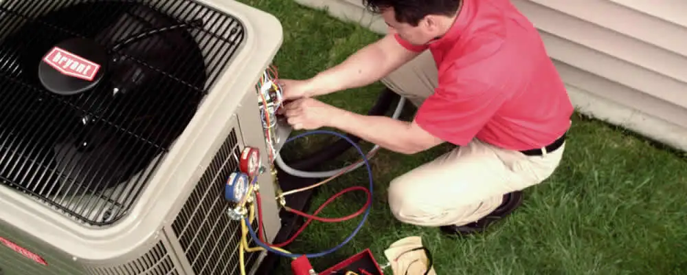 HVAC technician servicing an outdoor air conditioner unit in Dayton, OH