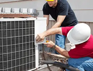 HVAC technicians repairing an outdoor AC unit on a rooftop in Dayton, OH
