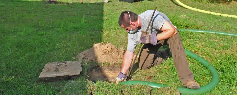 Septic pumping technician servicing a residential septic tank in Dayton, OH